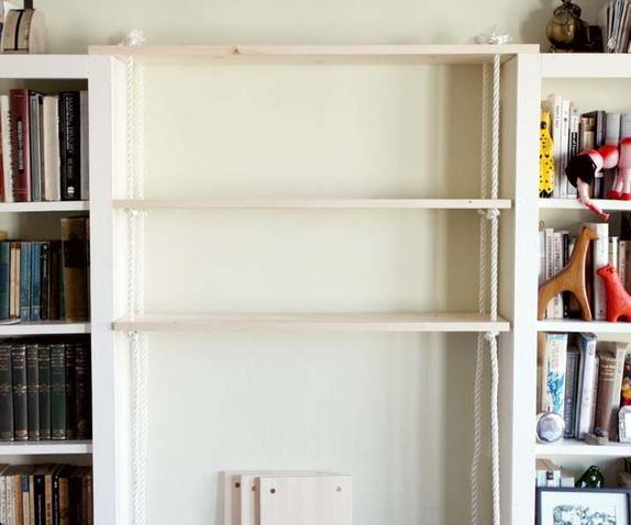 Между двумя книжными шкафами пустовало место, и я решила его использовать: там мы сделали удобные подвесные полки на веревке